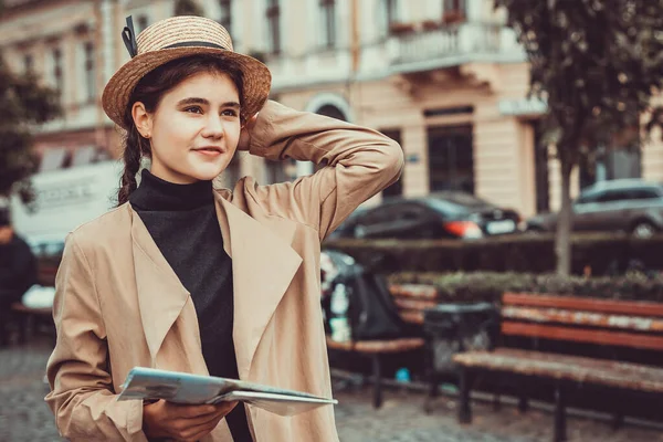 Прекрасна молода дівчина в солом'яному капелюсі і з картою в руці, дивлячись з великим бажанням побачити світ . — стокове фото