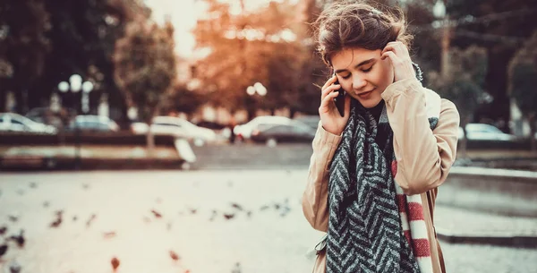 Gadis cantik berjalan-jalan di alun-alun penuh merpati, berbicara di telepon dan menikmati hari-hari hangat terakhir dalam setahun. — Stok Foto
