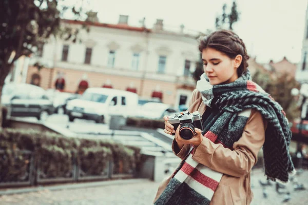 Gadis Kaukasia kreatif menonton pemandangan kota dan mengambil gambar arsitektur lokal. Fokus pada kamera antik. — Stok Foto