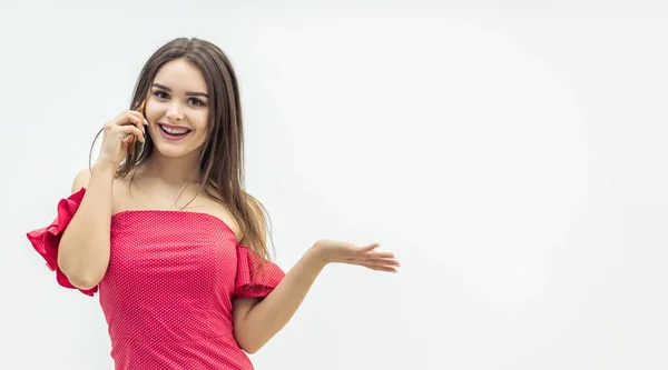 Leende kvinna talar i telefon, står isolerad på en vit bakgrund, bärs i trendiga sommar outfit. — Stockfoto