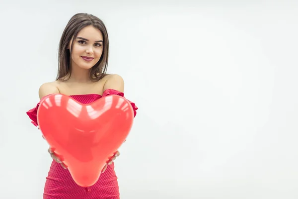 Mulher sorridente fica sobre fundo branco com balões em forma de coração vermelho nas mãos . — Fotografia de Stock