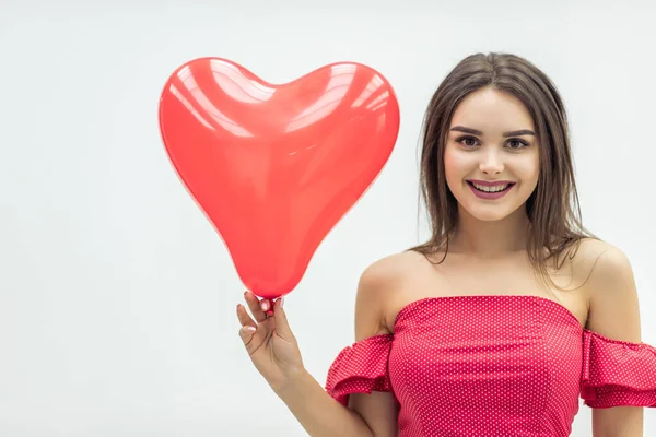 Mulher sorridente fica sobre fundo branco com balões em forma de coração vermelho nas mãos . — Fotografia de Stock