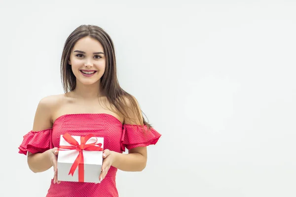 Radosna kobieta trzyma pudełko z prezentami i uśmiecha się na białym tle. — Zdjęcie stockowe