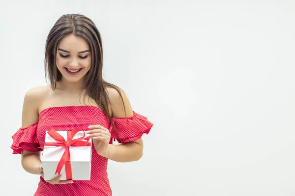 Glad kvinna som håller i en presentask och ler över en vit bakgrund. — Stockfoto