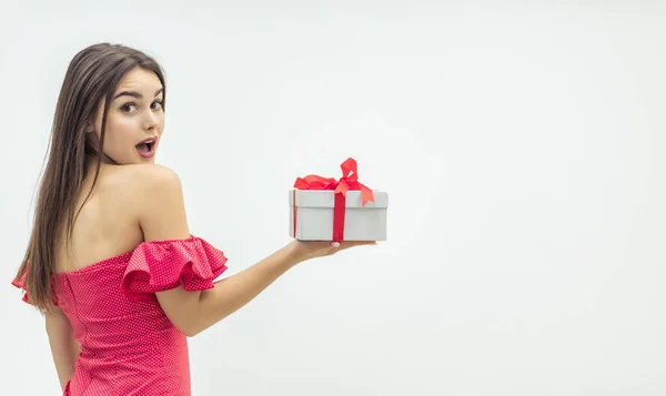 Julfirande koncept. Nyfiken ung kvinna håller en present låda ivrig att fing ut wht är inne. — Stockfoto