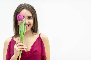 Neşeli bir bayan etrafta dolanıp gözlerini bir lale çiçeğinin arkasına saklar ve aptal suratlar yapar..