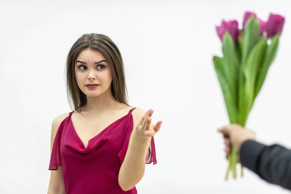 Vacker kvinna med snobbiga uttryck, tittar med skeptiska uttryck på en massa tulpaner hennes man ger henne. — Stockfoto