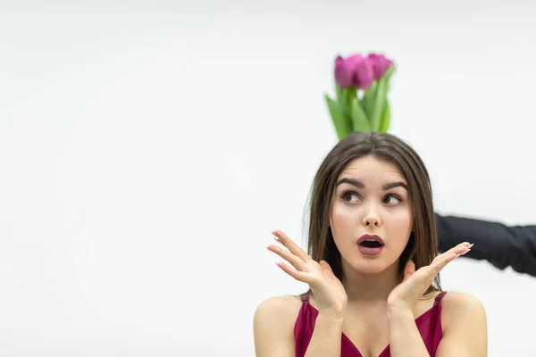 Surprised woman receive bouquet of pink tulip flowers over white background. — Stock Photo, Image