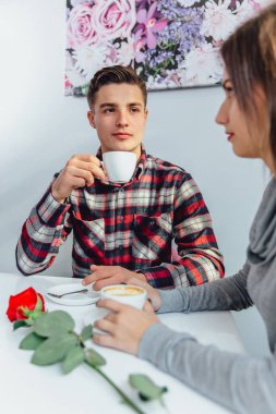Bir çift kafede oturuyor, kahve içiyor, sakin görünüyor, ama aralarında gerginlik var..
