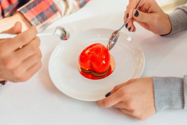 Kalp şeklinde mus tatlısı ve insanların elleri, kaşıklar, bu şekeri tatmak, Sevgililer Günü 'nü kutlamak..