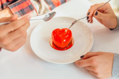 Kalp şeklinde mus tatlısı ve insanların elleri, kaşıklar, bu şekeri tatmak, Sevgililer Günü 'nü kutlamak..