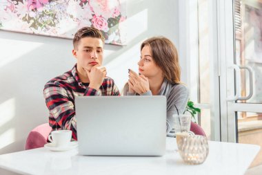 Kafede kahvaltı yaparken dizüstü bilgisayarda çalışan iki serbest çalışan ve kahvenin tadını çıkaran.