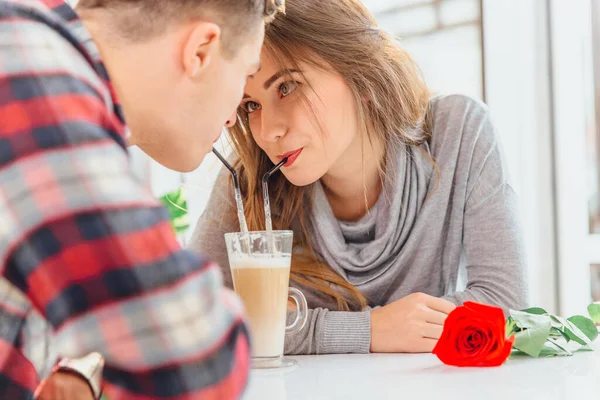 A fiatalok romantikus találkozón, együtt kávéznak, és érdekes csábító arckifejezéssel, flörtöléssel néznek egymásra.. — Stock Fotó