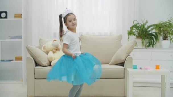 Söt liten prinsessa i kronan poserar, vänder sig i vacker klänning, ler. — Stockvideo