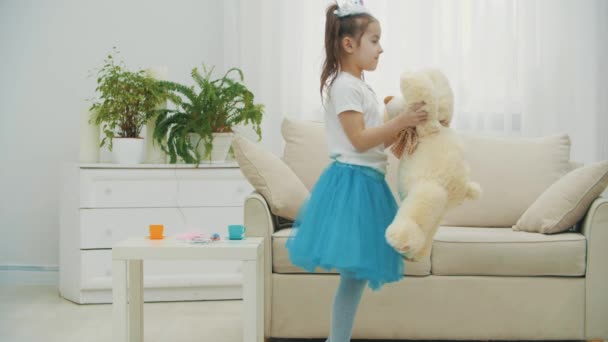 Kleine prinses danst met haar beste vriendin teddybeer, draait zich vrolijk om, staat dan te zwaaien hallo door beren poot. — Stockvideo