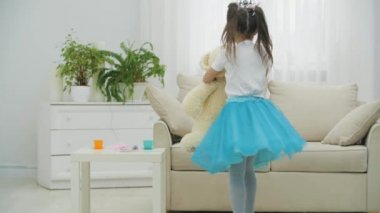 Küçük prenses en iyi arkadaşı oyuncak ayıyla dans ediyor, sevinçle dönüyor..