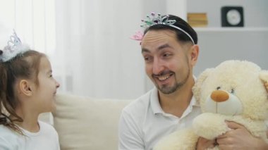 Prenses tacındaki komik baba, çocuksu görünüyor. Küçük kızım ona gülüyor. Sarılıyorlar..