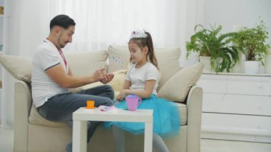 Sevgili kızım üzgün. Babam onu sakinleştiriyor. Küçük prenses için en iyi tacı seçiyorlar..