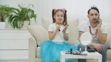 Yakışıklı bir genç adam telefonda konuşuyordu. Kızı, babası için makyaj yapmaya hazır. Babalar Günün kutlu olsun..