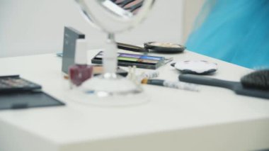 Kamera kozmetik malzemelerle dolu masada hareket ediyor, sonra da babasına makyaj yapan sevimli çocuğa odaklanıyor..