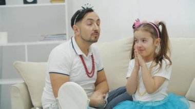 Küçük çocuk babası için makyaj yapıyor. Babam korkuyor, gözlerini kapatıyor..