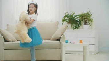 Küçük prenses en iyi arkadaşı oyuncak ayıyla dans ediyor, sevinçle dönüyor..