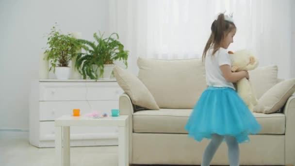 Mała księżniczka tańczy ze swoim najlepszym przyjacielem pluszowym miśkiem, obracając się radośnie. — Wideo stockowe