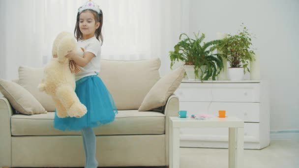 Pequeña princesa está bailando con su mejor amigo osito de peluche, girando alegremente alrededor. — Vídeo de stock