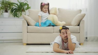 Küçük kız, onunla oynamaktan yorulan babasına sarılıyor..