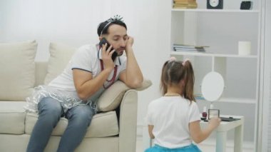 Yakışıklı bir genç adam telefonda konuşuyordu. Kızı, babası için makyaj yapmaya hazır. Babalar Günün kutlu olsun..