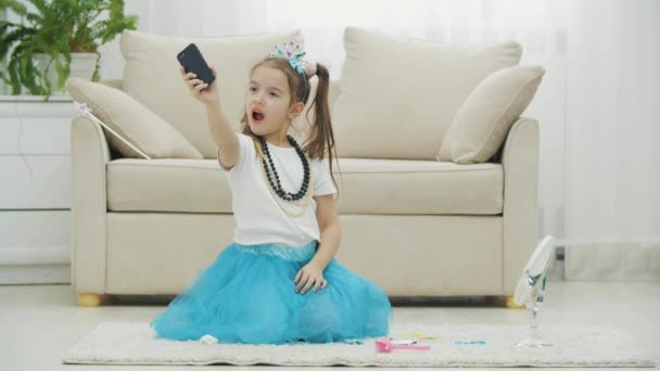 Krásné malé dítě s korunou, šaty, náhrdelník, a přičemž selfie, pózování. — Stock video