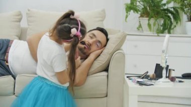 Tatlı küçük çocuk uyurken babasının dudaklarına pembe ruj sürüyor. Babam uyandı, kafası karışmış görünüyordu, ne olduğunu anlamıyordu..