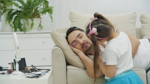 Lindo niño pequeño poniendo lápiz labial rosa en los labios papis mientras duerme. Padre se despierta, se mira en el espejo, sonriendo. — Vídeos de Stock