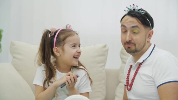 Sonriente chica sosteniendo cepillo y polvo de la cara, padre está apuntando a su párpado con sombras de ojos amarillos. — Vídeos de Stock