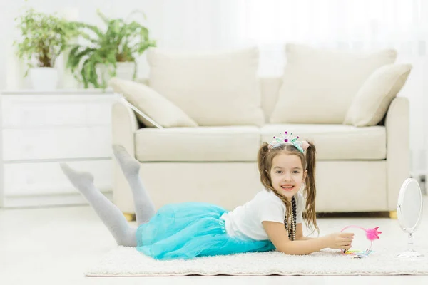 Photo of little girl wearing blue skirt laying on the floor. — Stock Photo, Image