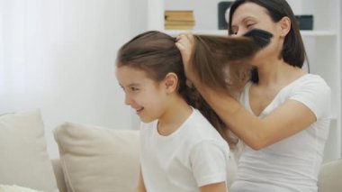 Anne kızını tarıyor, saçını at kuyruğu yapıyor..