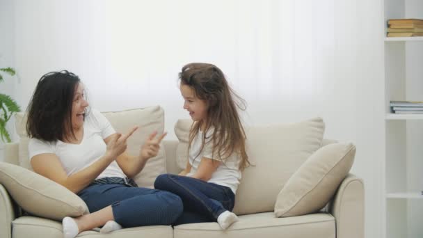 Funny mum is pointing at daughters tousled hair, laughing, then tickling her. — Stock Video