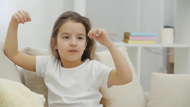 4k wideo z małą dziewczynką bawiącą się samotnie siedząc w domu. — Wideo stockowe