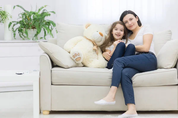 Φωτογραφία της μητέρας και της κόρης της να κάθονται μαζί σε λευκό καναπέ. — Φωτογραφία Αρχείου