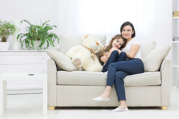 Фотографія матері та її дочки, що сидить разом на білому дивані . — стокове фото