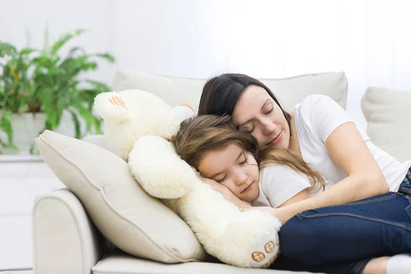 Фото маленької дівчинки з мамою, яка спить на дивані . — стокове фото