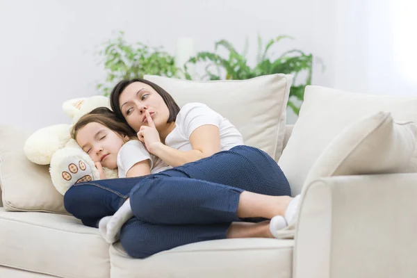 Foto de mamá mostrando señal de silencio mientras su hija duerme. — Foto de Stock