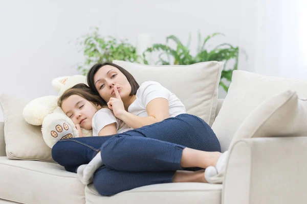 Foto de mamá mostrando señal de silencio mientras su hija duerme. — Foto de Stock