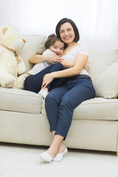 Фотографія матері та дочки на білому дивані . — стокове фото