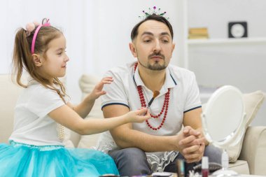 Sevimli küçük kızı ve taç giymiş yakışıklı babası birlikte oynuyorlar..