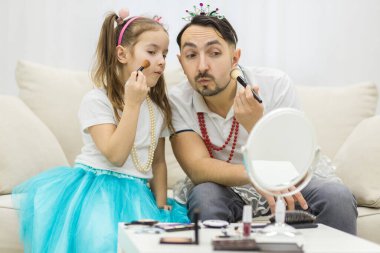 Sevimli küçük kızı ve taç giymiş yakışıklı babası birlikte oynuyorlar..