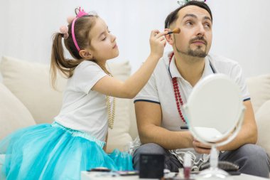 Sevimli küçük kız babasına makyaj yapıyor..