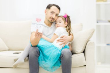 Kızının babasını kartpostalla selamlamak istediğinin fotoğrafı..