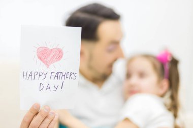 Mutlu aile kızı tatilde babasına bir tebrik kartı veriyor..