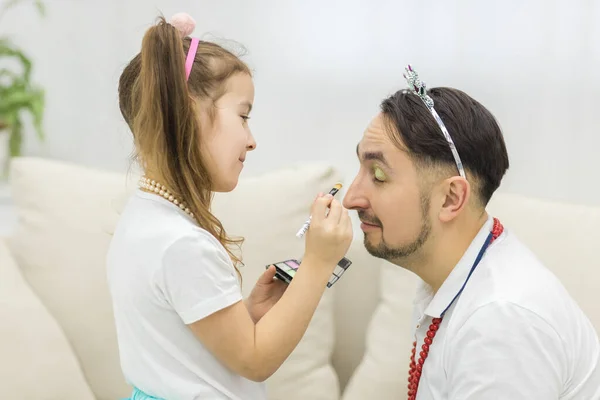 Vista lateral de la hija haciendo maquillaje para su papá. —  Fotos de Stock